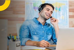 Un agente de viajes, sonriente, en su portátil, presentando los servicios turísticos de su empresa.