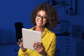 Una mujer con anteojos, estudiando los programas de CET en su tablet.