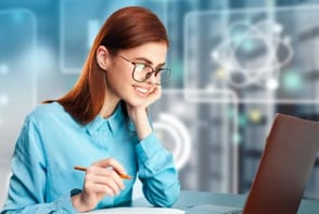 Una mujer con anteojos, tomando apuntes sobre su curso de fundamentos en analítica de datos