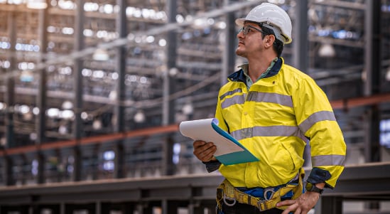 Un hombre, egresado del tecnólogo en Gestión de Calidad, Seguridad y Salud de CET, revisando los procesos de su empresa.