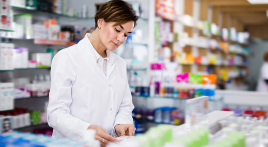 Una mujer vestida de blanco revisando los depósitos mayoristas de medicamentos.