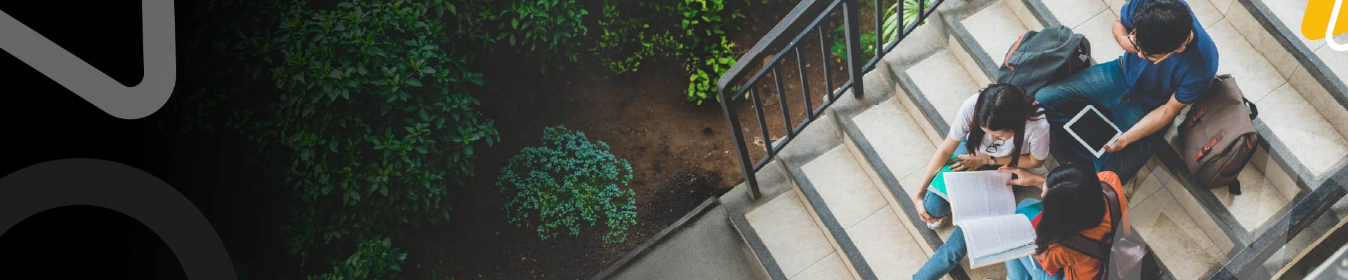 Estudiantes de Tec Alianza comparten material académico en las escaleras de una institución educativa.