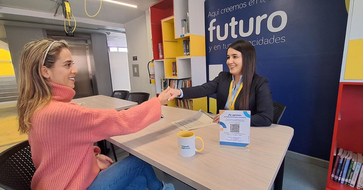 Una estudiante de CET da la mano a una asesora comercial porque acaba de financiar su matrícula en cuotas, con 0 % de interés. 